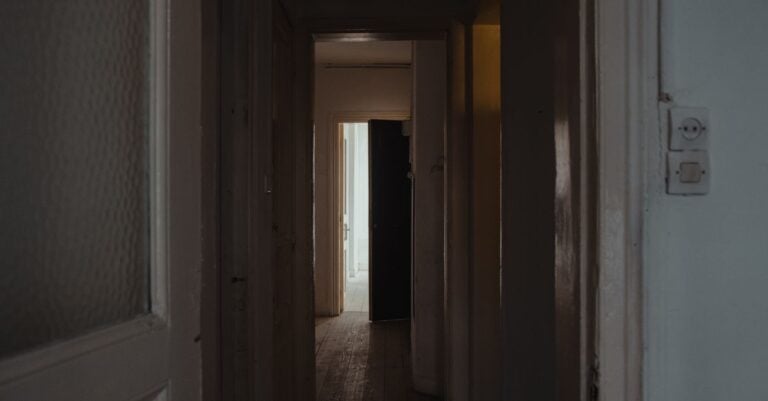 A dim hallway leading toward an open doorway
