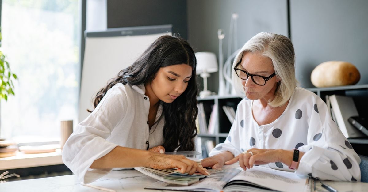 Two women working through a document together at a desk