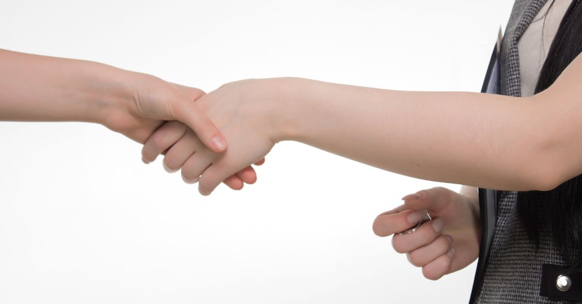 Two people shaking hands against a white background