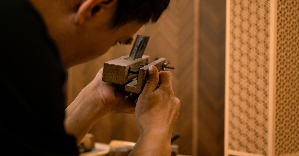 Skilled artisan working on traditional wood joinery technique indoors.