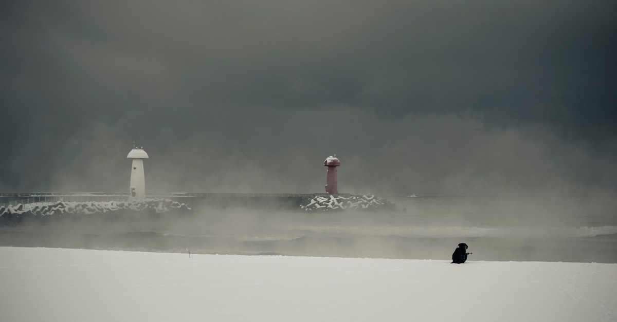 Snowy scene with lighthouses shrouded in mist at Yangyang, South Korea.